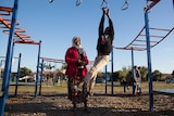 Kadiga supervises her second-youngest son Maher on the monkey bars