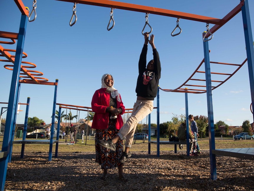 Kadiga supervises her second-youngest son Maher on the monkey bars