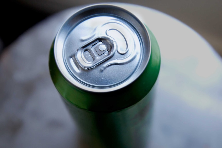 A green energy drink can seen from above its pull tab