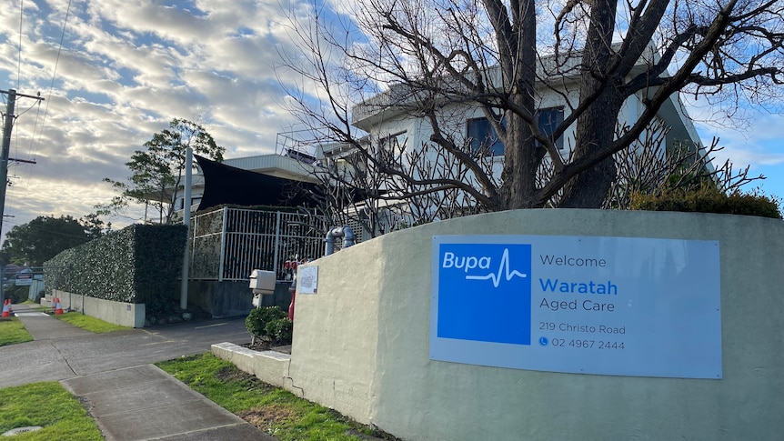 A nursing home with "Bupa" branding on a wall in front of it.