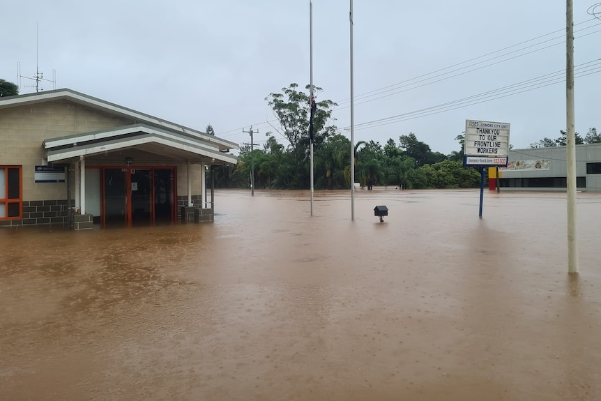 A building and sign surrounded by floodwater