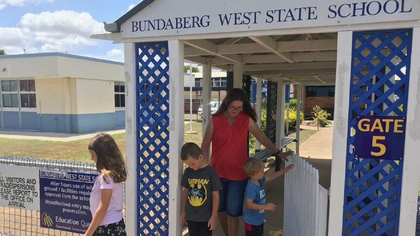 Meg Symes and her 3 children walking outside their school Bundaberg West State School.