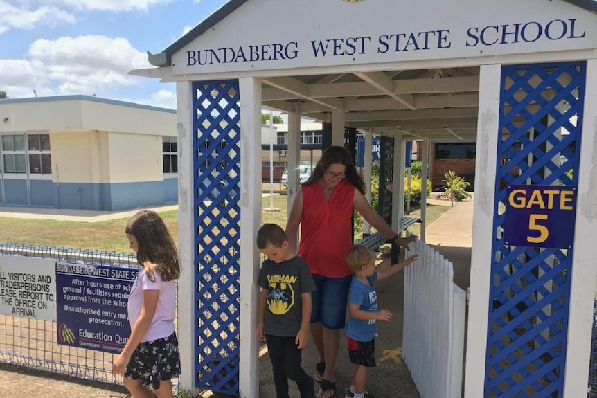 Meg Symes and her 3 children walking outside their school Bundaberg West State School.