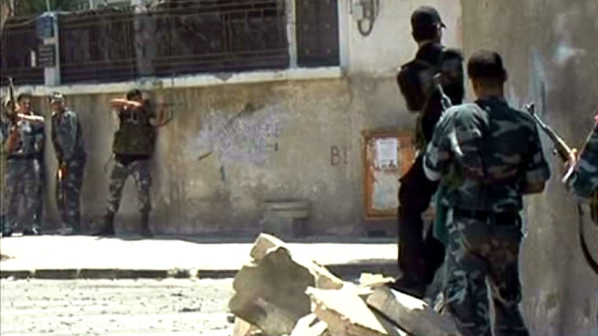 Syrian security forces take position during clashes with gunmen in the Al-Midan district of Damascus.