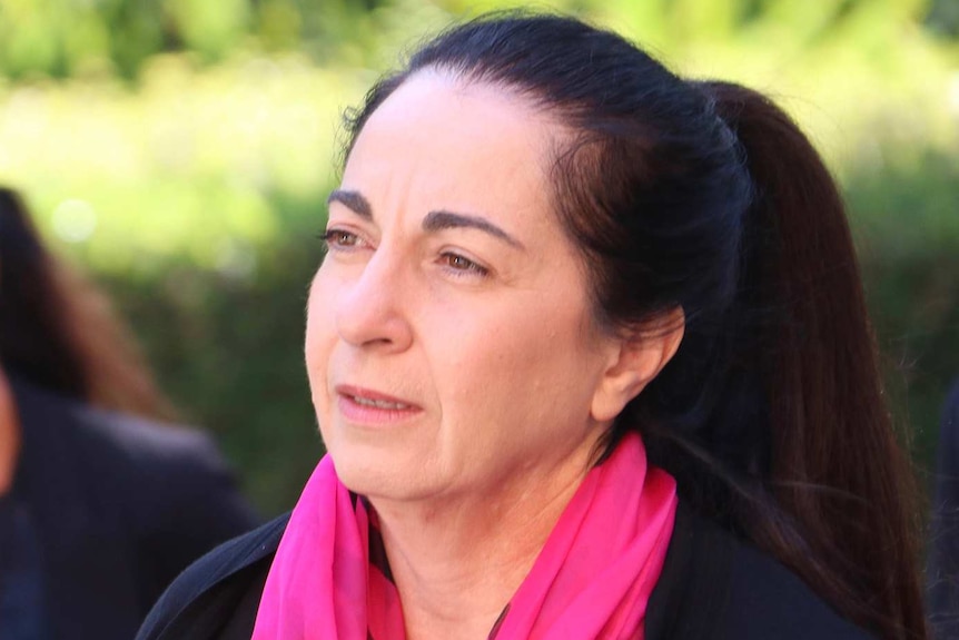 A lawyer wearing a black top and pink scarf outside the Supreme Court.