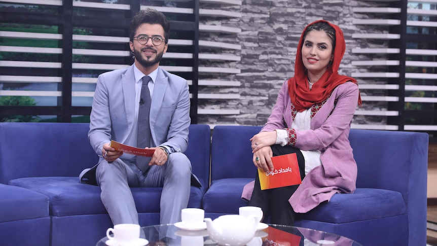 A female presenter in a headscarf and a man present a TV program in Afghanistan 