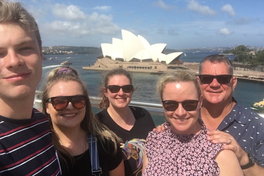 Two men and three women in front of the Sydney Opera House.
