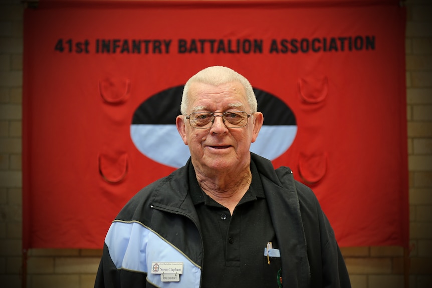 Norman Clapham in front of the 41st Battalion banner