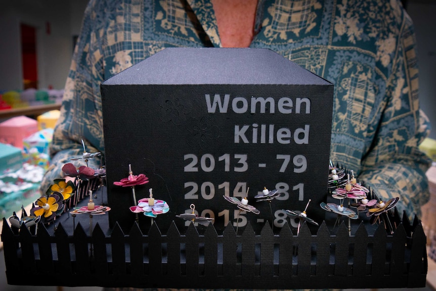 A black cardboard memorial with a picket fence lists the women killed in 2013 as 79, in 2014 as 81 and in 2015 as 80.