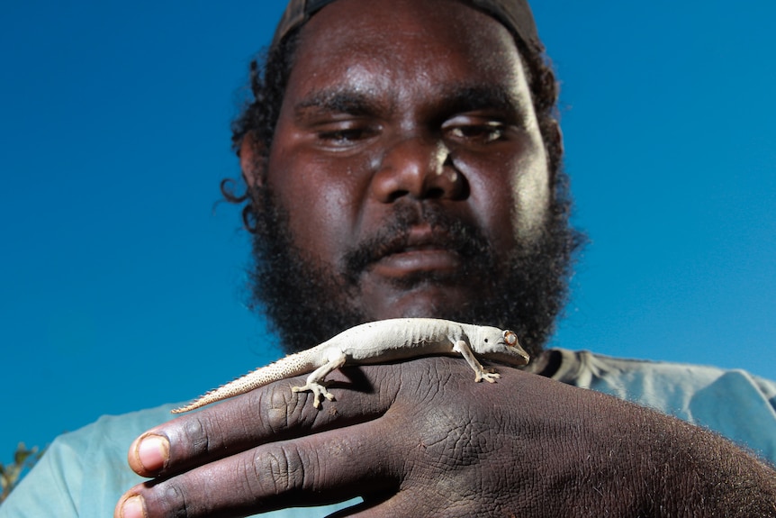 A man with a lizard on his hand.