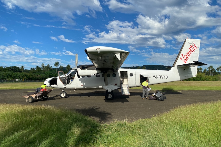 Mały samolot zostaje załadowany na przybrzeżną wyspę w Vanuatu.