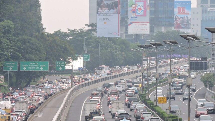Cars sit in a traffic jam down a major Jakarta thoroughfare.