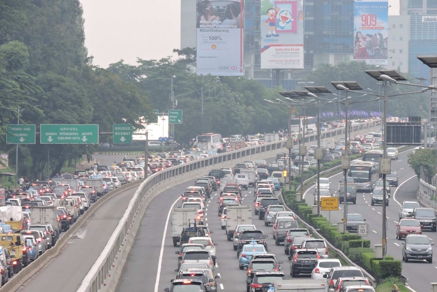 Cars sit in a traffic jam down a major Jakarta thoroughfare.