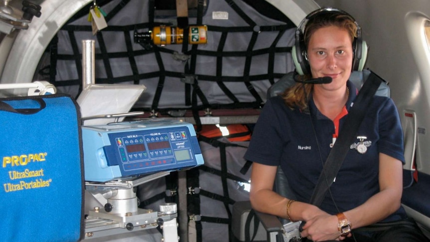 Nurse sitting in a small plane with medical equipment.