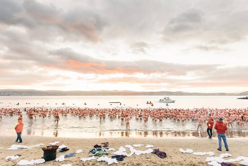 Swimmers enter the water at Long Beach for Dark Mofo winter solstice 2017 event.