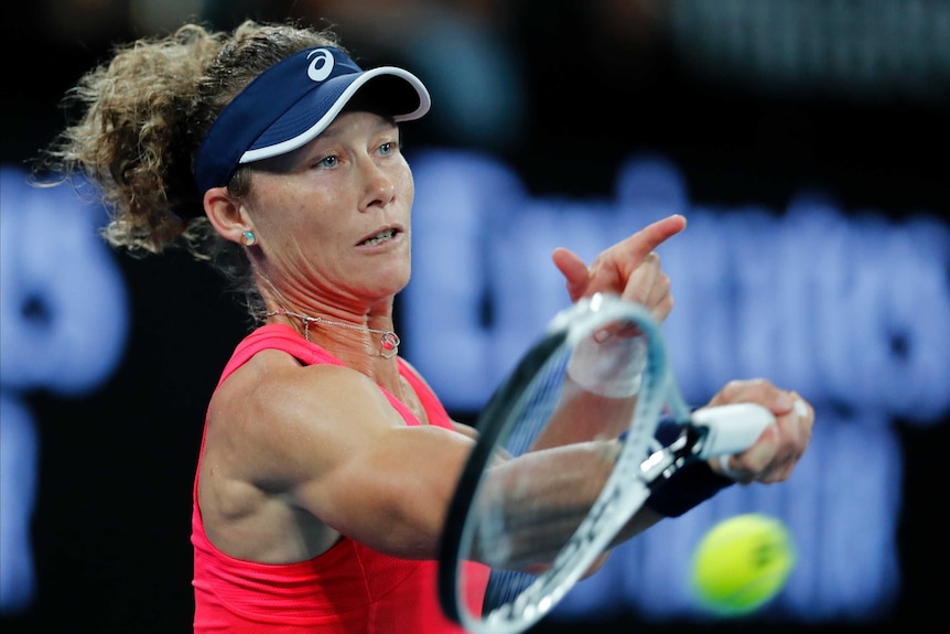 A tennis ball flies off Sam Stosur's racket as she hits a forehand.