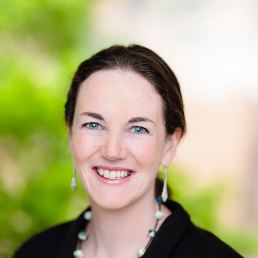 Dr Robyn Schofield smiling, with plants behind her.