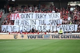 Wanderers fans hold a banner before walking out in protest over the names of banned spectators being published in a newspaper.