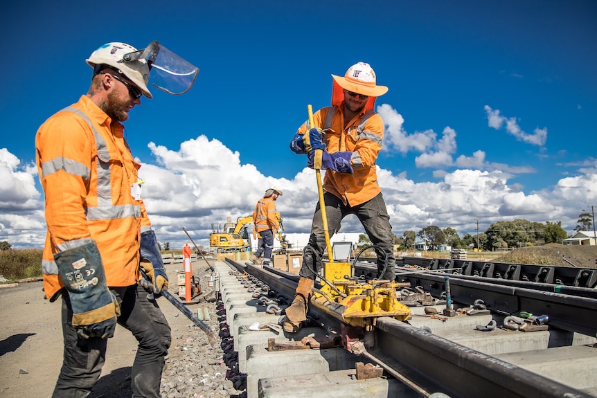 Workers installing railway sleepers on Inland Rail from ARTC Facebook post, July 2022.
