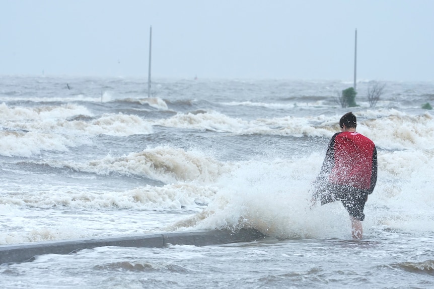 A person watches the wind and waves at the Gulfport Municipal Marina as outer bands of Hurricane Ida