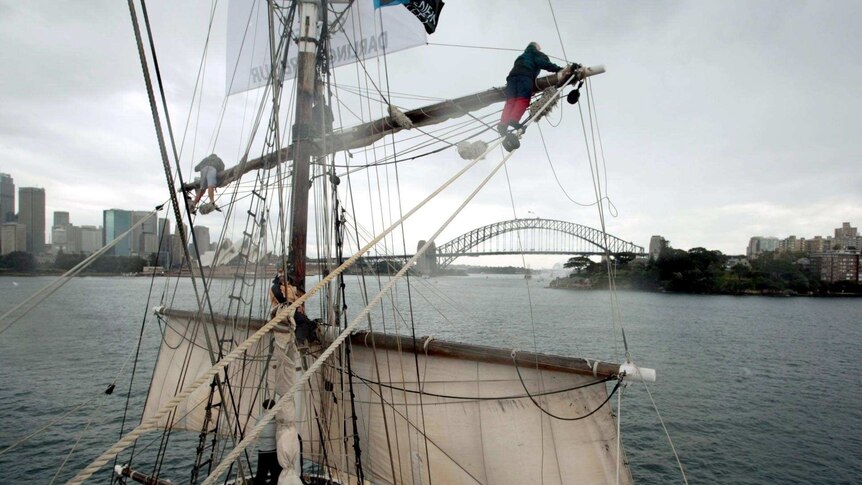 A tall ship approaches the Sydney Harbour Bridge.