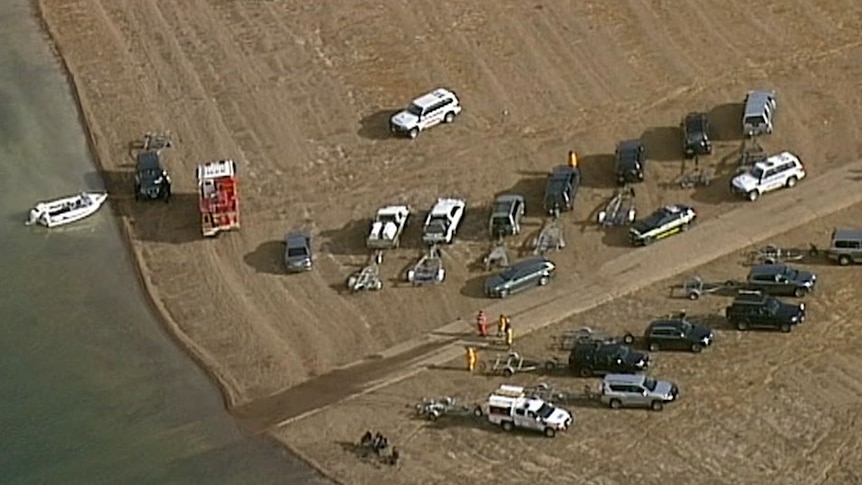 Rescue crews at the edge of the water where an ultralight crashed.