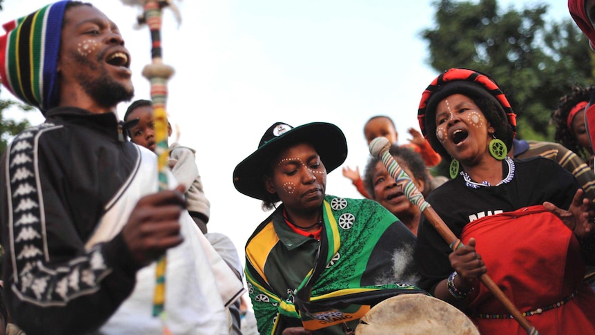 South Africans sing to honour the life of Nelson Mandela outside his home in Johannesburg