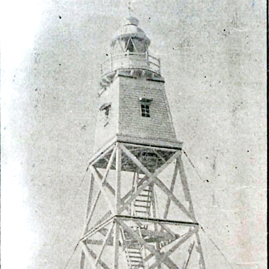 A faded black and white photo of a lighthouse.