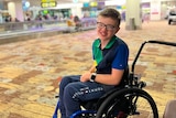 A young boy in a wheelchair at an airport