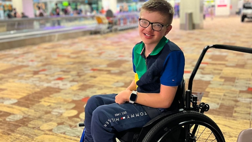 A young boy in a wheelchair at an airport