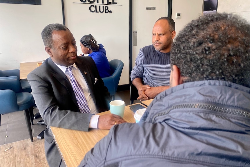 Accountant Kennedy Weldermariam talks with two friends at a cafe 