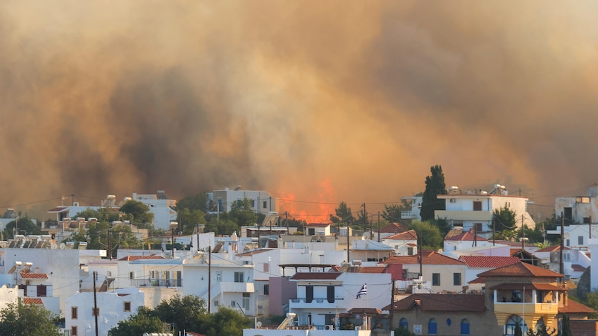 a greek island with fire in the background 