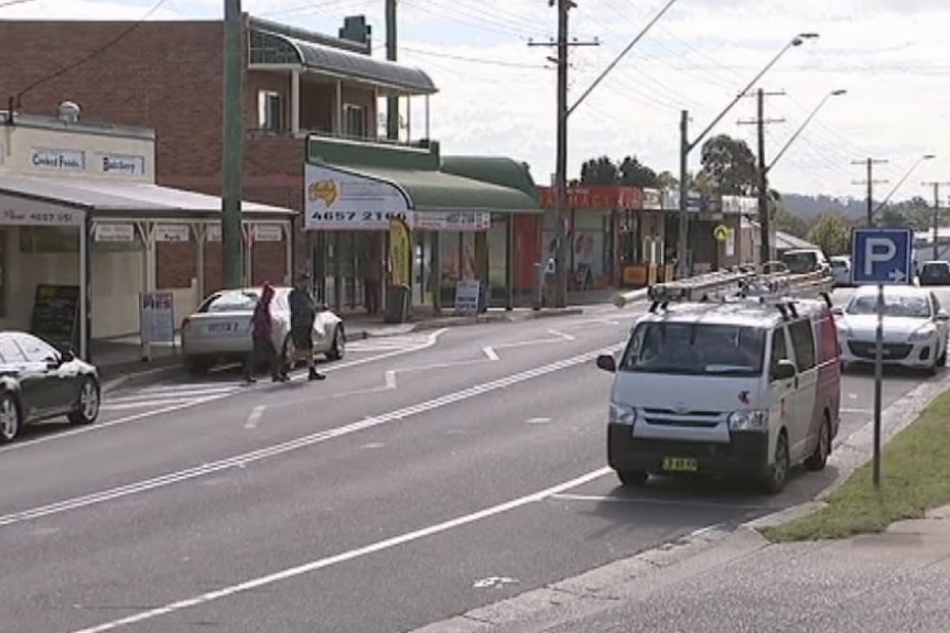 A main street with shops and cars.