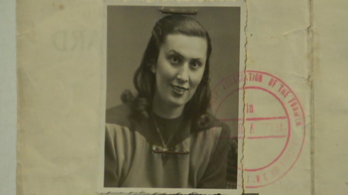 Faded yellow passport-style papers show a picture of a woman in black and white.