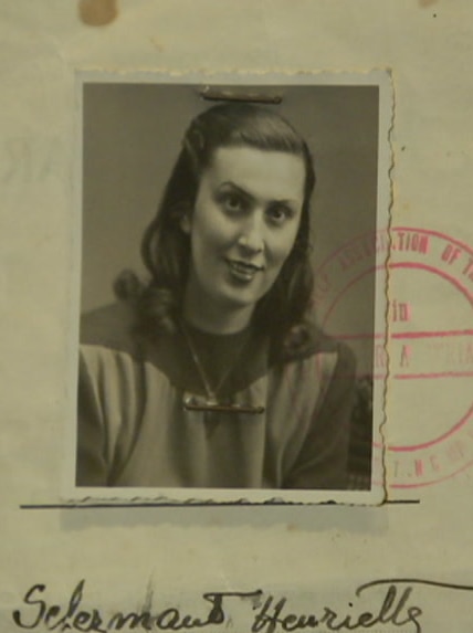 Faded yellow passport-style papers show a picture of a woman in black and white.