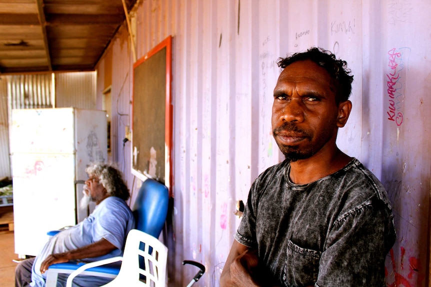 Eric West and his uncle Bobby sit outside a building in the remote Western Australia community of Kiwirrkurra