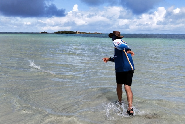 Steve Mills walking into crystal clear blue waters off the coast of Lockhart River, far north Queensland.