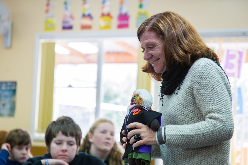 Dlalanathi ambassador Robyn Hemmens shows the school children the Uthando dolls that help South African children.