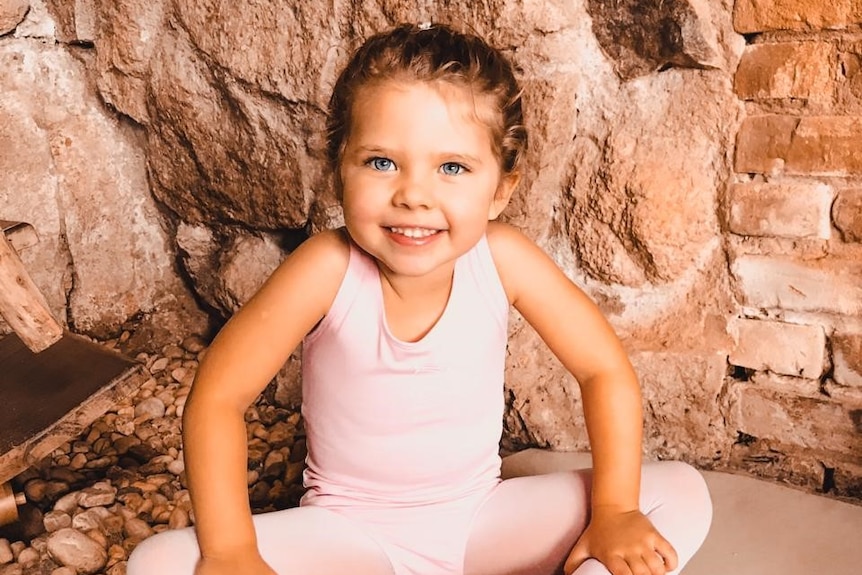 A young girl smiles at the camera.