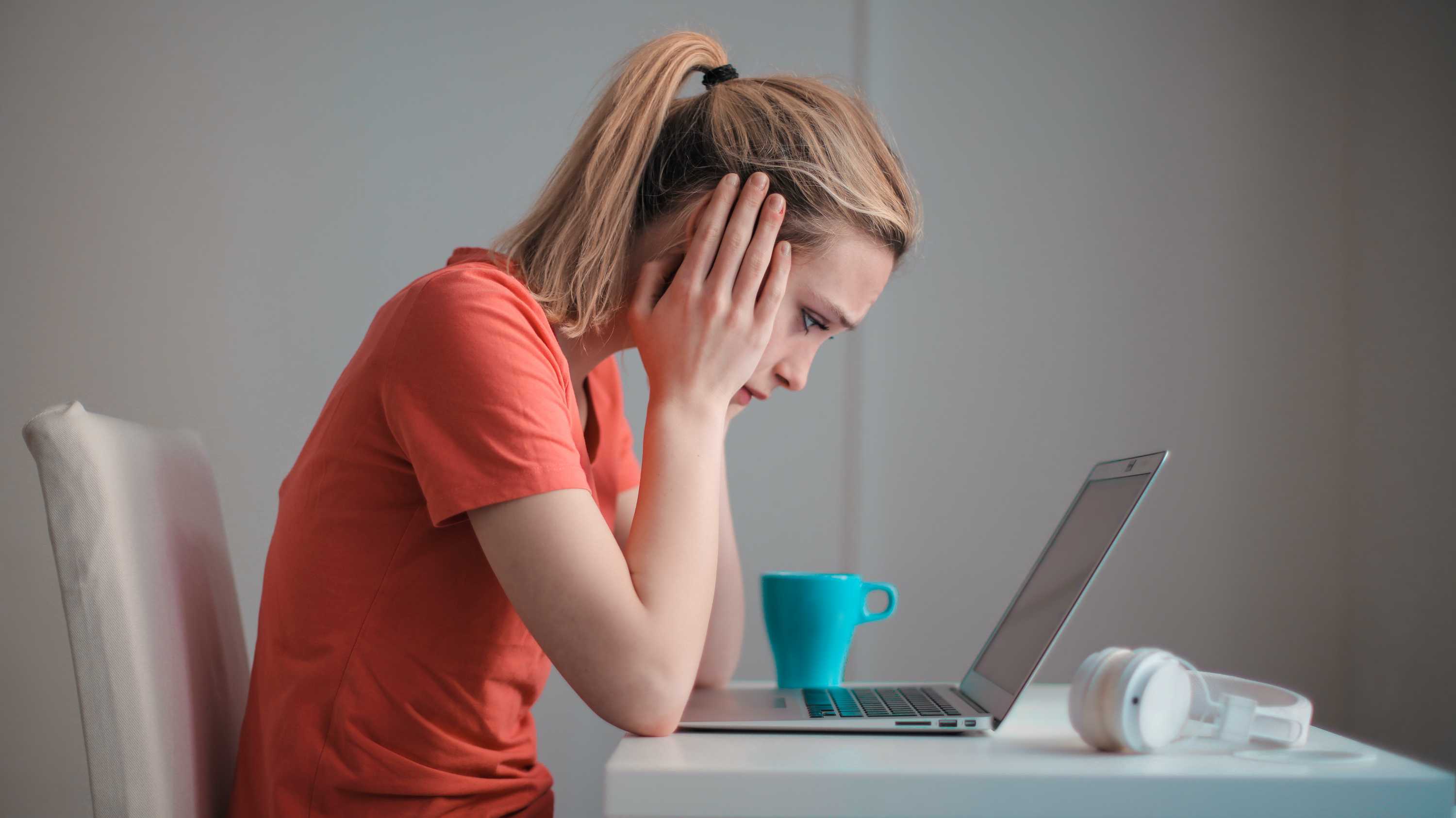 Woman looks at laptop screen, for a story about energy bill shock.