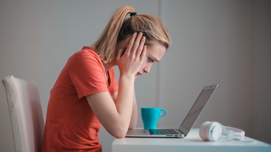 女人看着笔记本电脑屏幕，是为了了解一个关于能源账单冲击的故事。