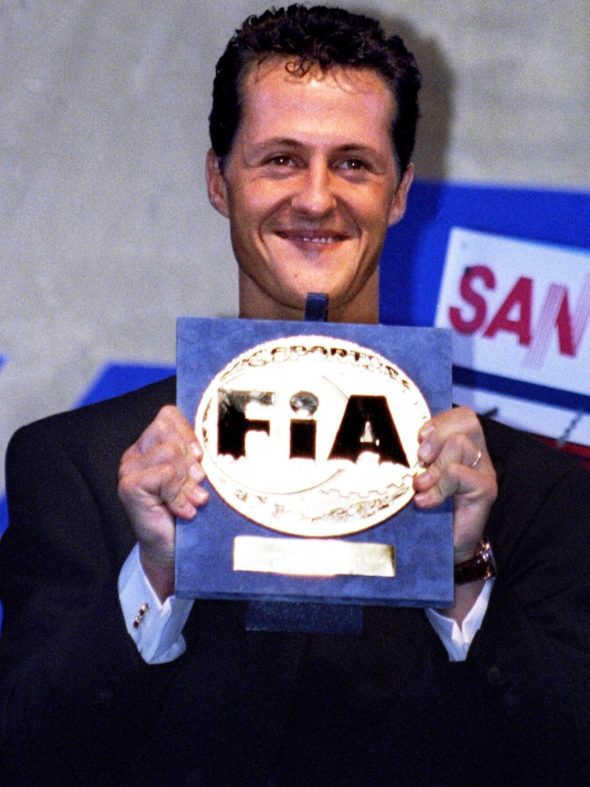 Michael Schumacher holds the 1994 World Champion trophy.