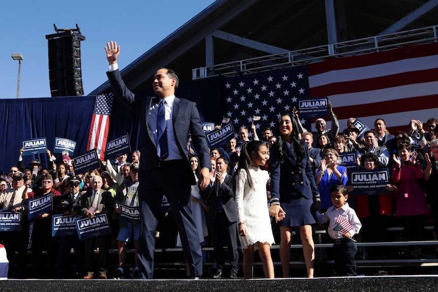Julian Castro waves to the crowd at his rally with his family on stage