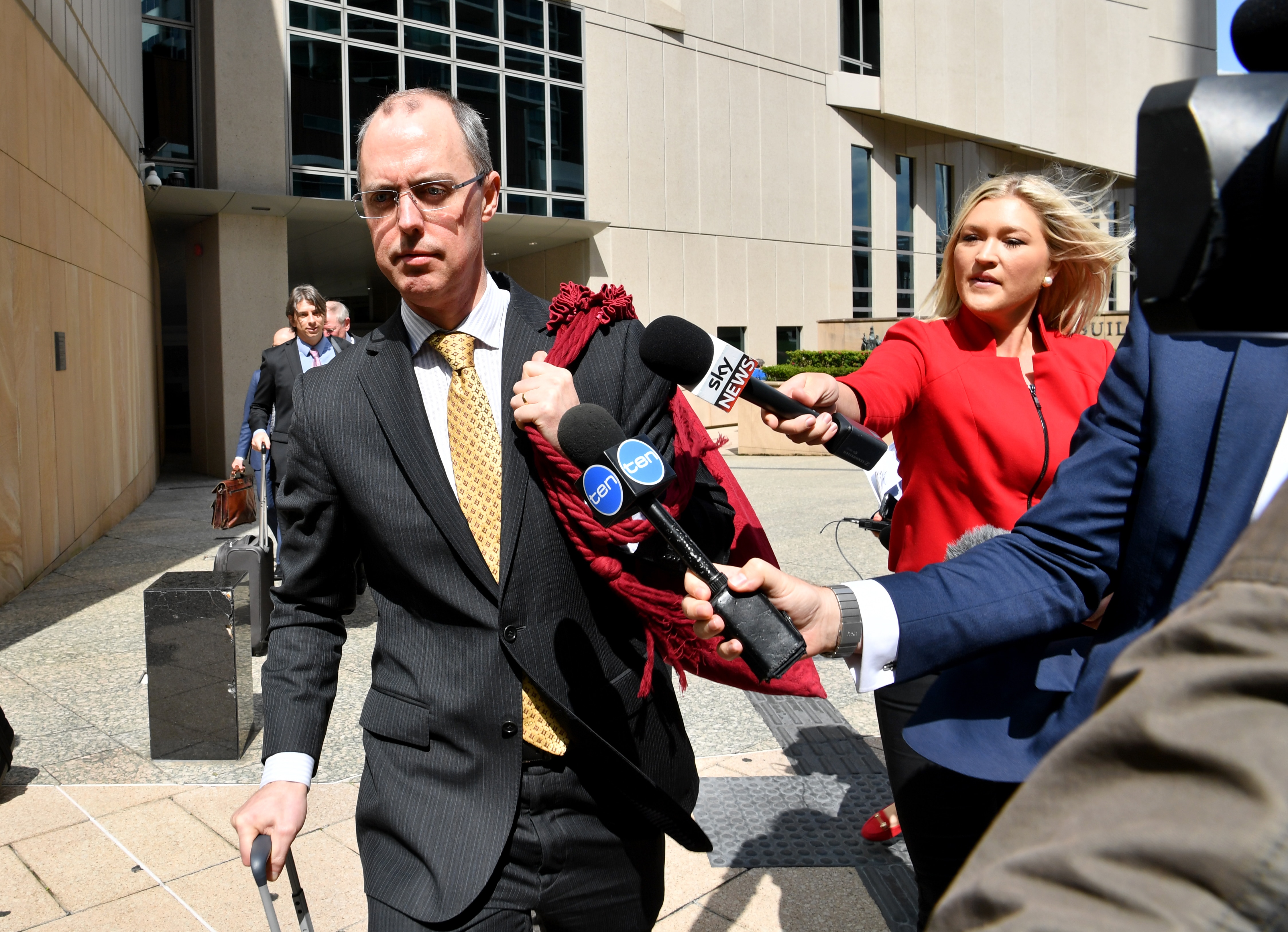 Stephen Donaghue walks past the media as he leaves the High Court carrying a red bag