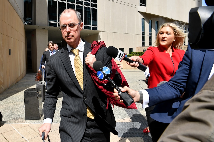 Stephen Donaghue walks past the media as he leaves the High Court carrying a red bag