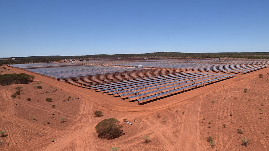 aerial view of solar collectors in a red soil outback area