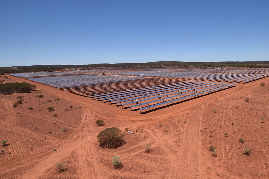 aerial view of solar collectors in a red soil outback area