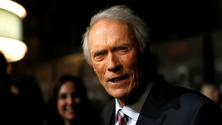 Clint Eastwood wearing a suit at a movie premiere.