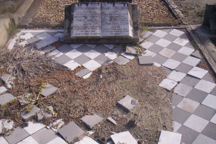 A dishevelled grave overgrown with weeds