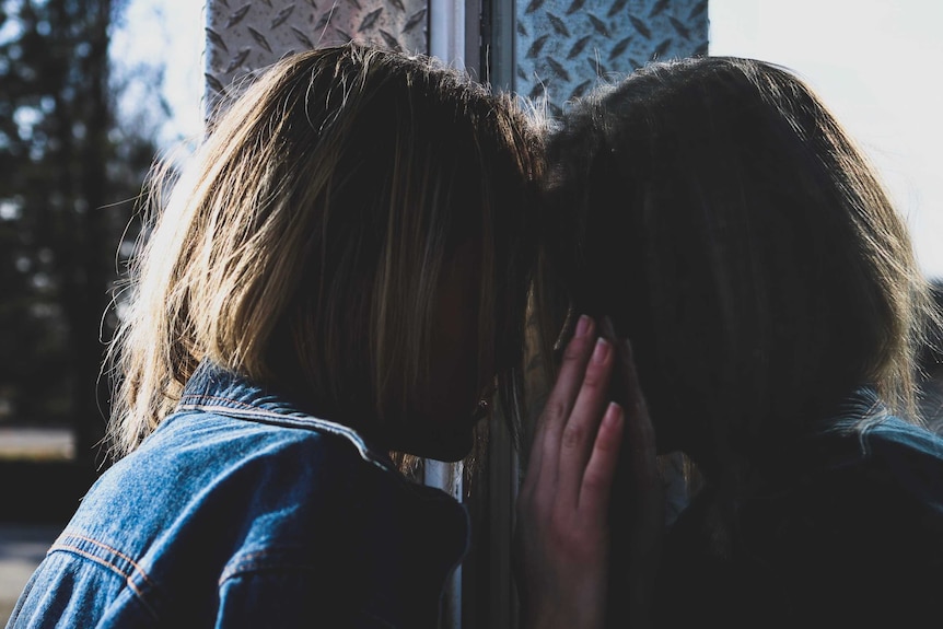 Young person peering through window.